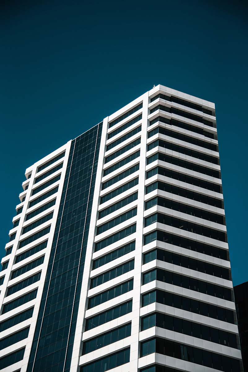 building low angle photo of white curtain wall building town